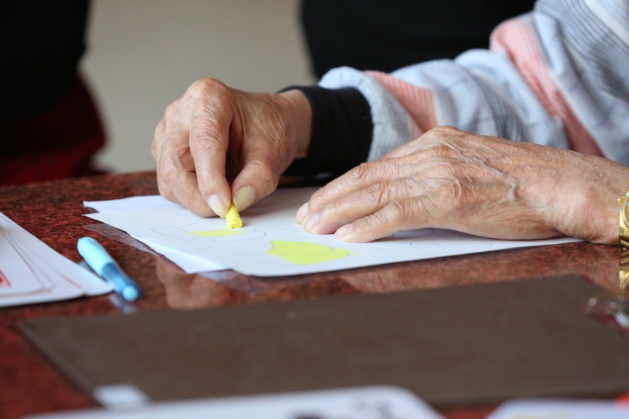 senior adult coloring a picture with arthritic hands