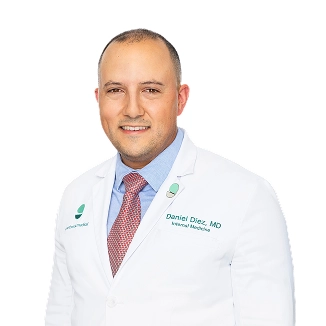 Dr. Daniel Diez, MD, wearing a white lab coat and a red tie