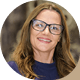 Adrian Taylor, a woman with glasses and brown hair, smiles.
